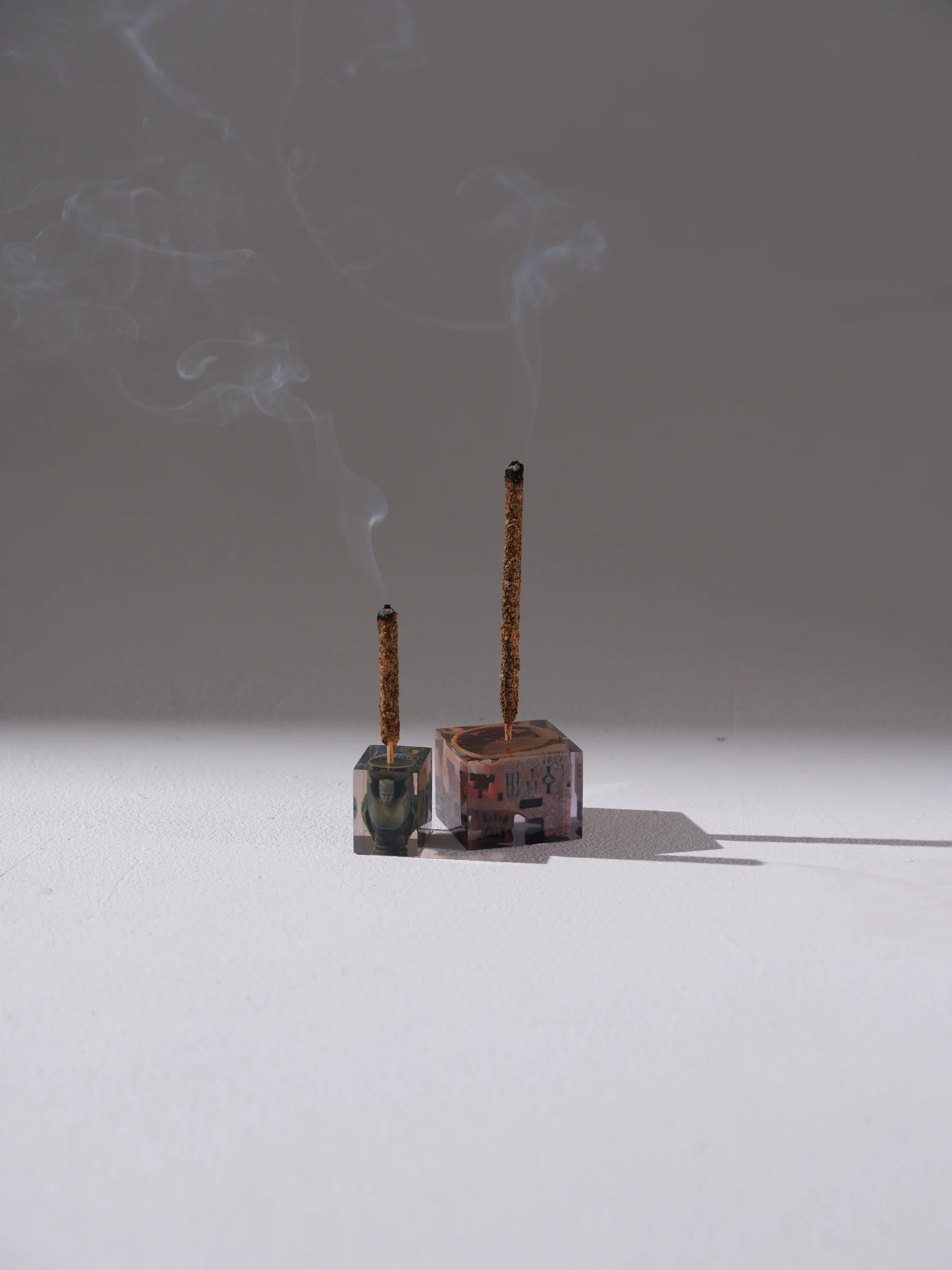 Two incense objects with rising smoke